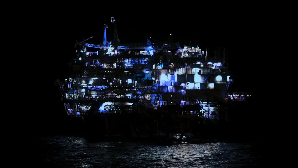 Plataforma offshore iluminada, isolada no mar durante a noite
